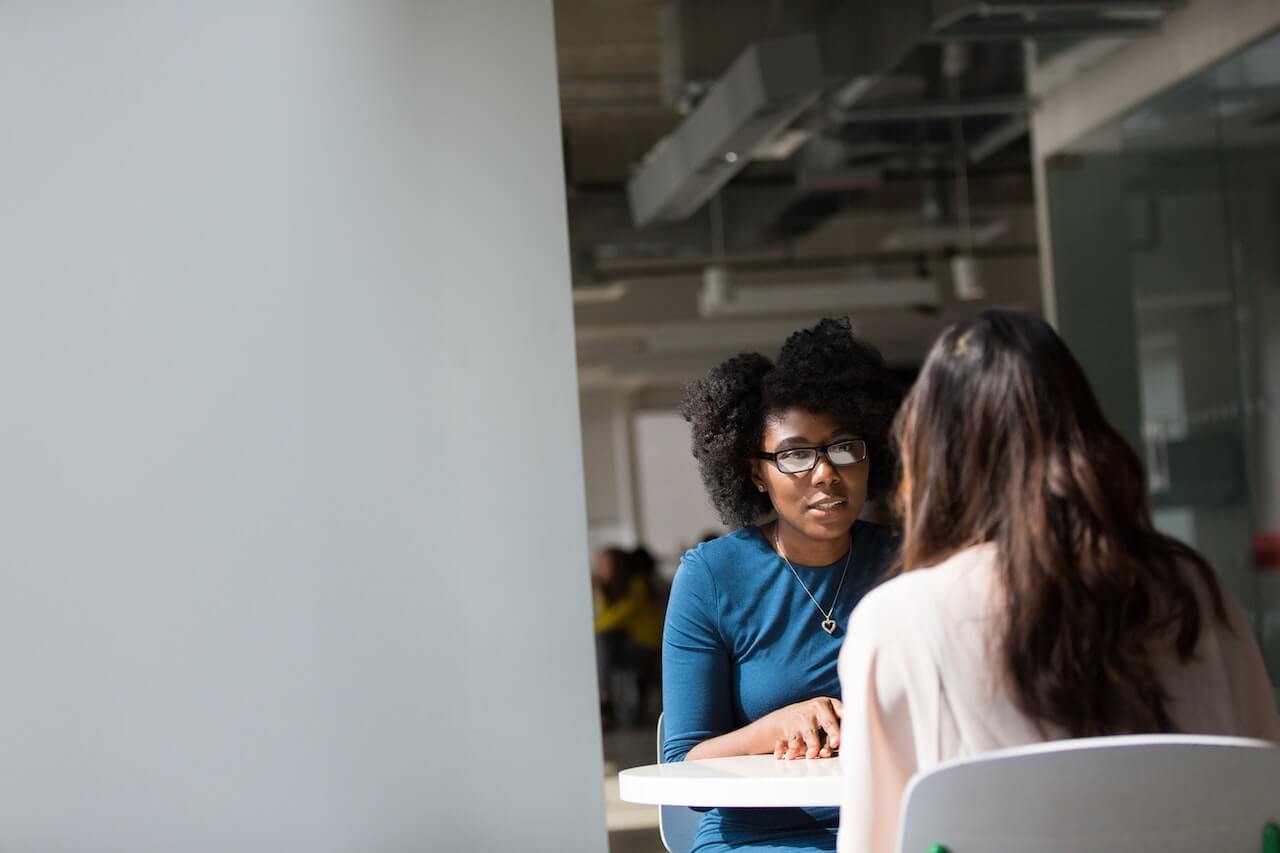 a woman sitting at a table with another woman