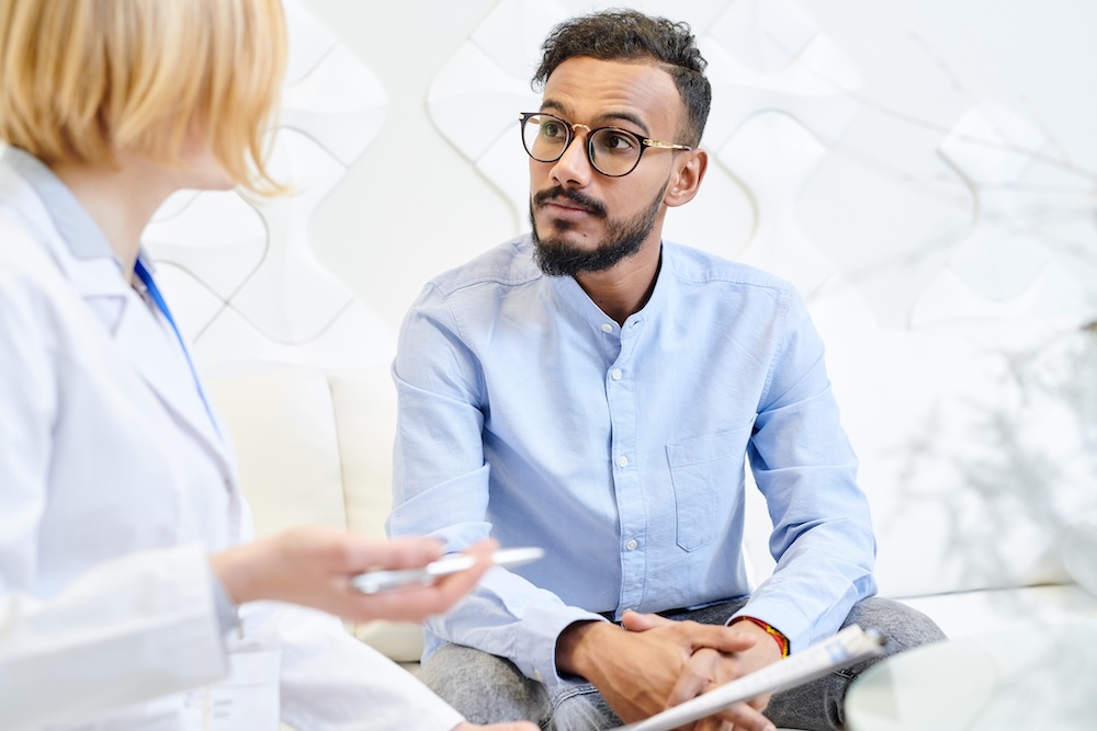 Young male patient talking to physician