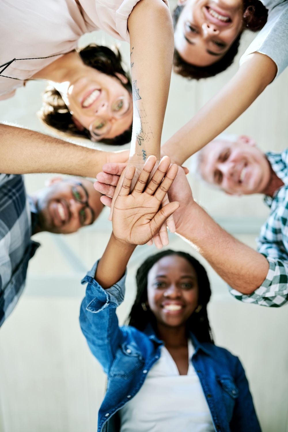 Group of community members putting their hands in a circle