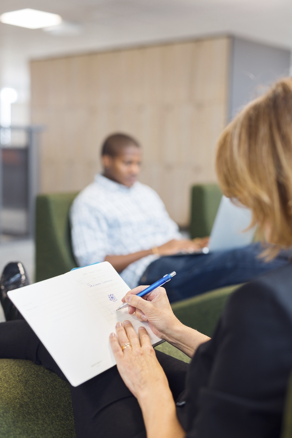 Therapist taking notes during session with patient