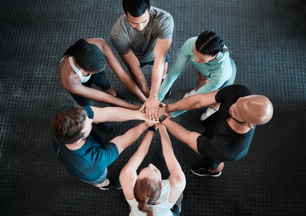 Shot of a group of friends with their hands stacked in support