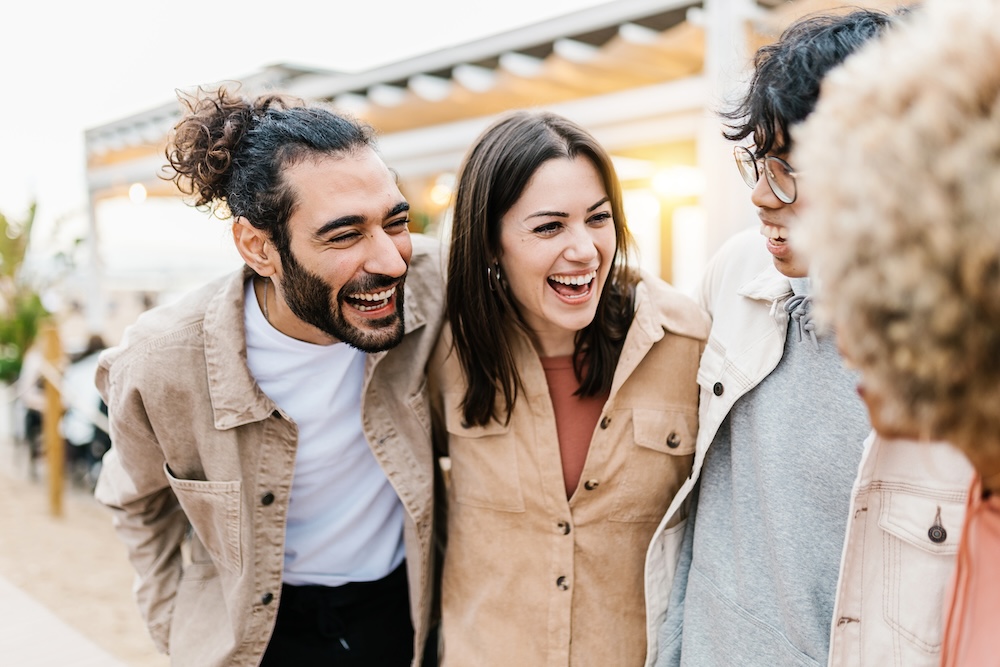 Millennial people laughing together outdoors