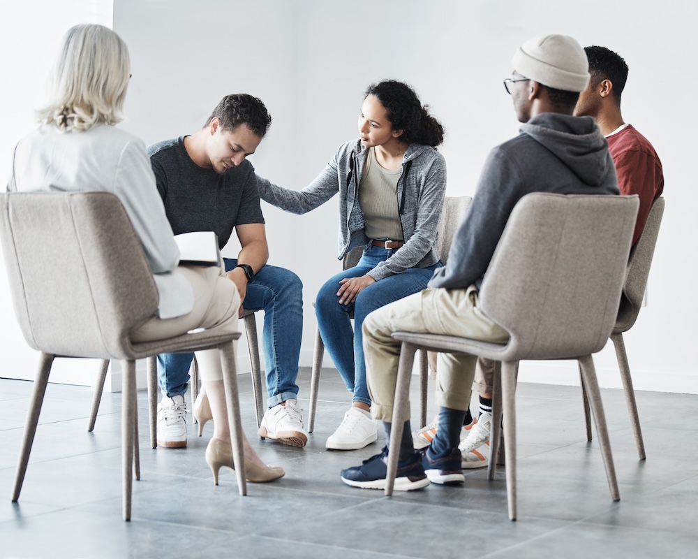 Clients offering support during group therapy session about addiction