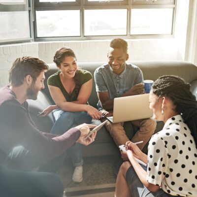 Shot of a team of young adults having a meeting on a sofa in a modern space.