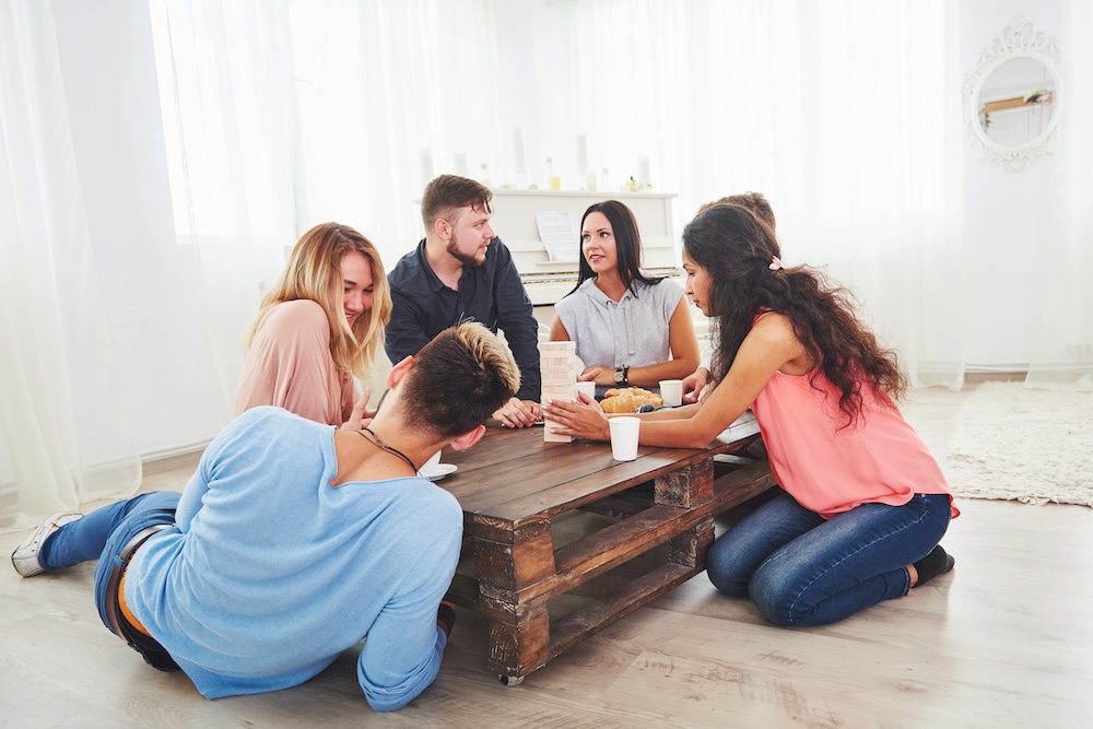 Group of creative friends sitting at wooden table