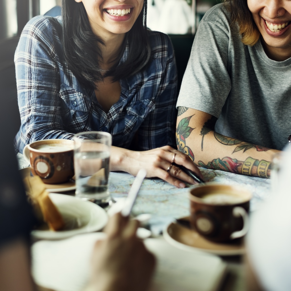 Group of happy friends in recovery drinking coffee together