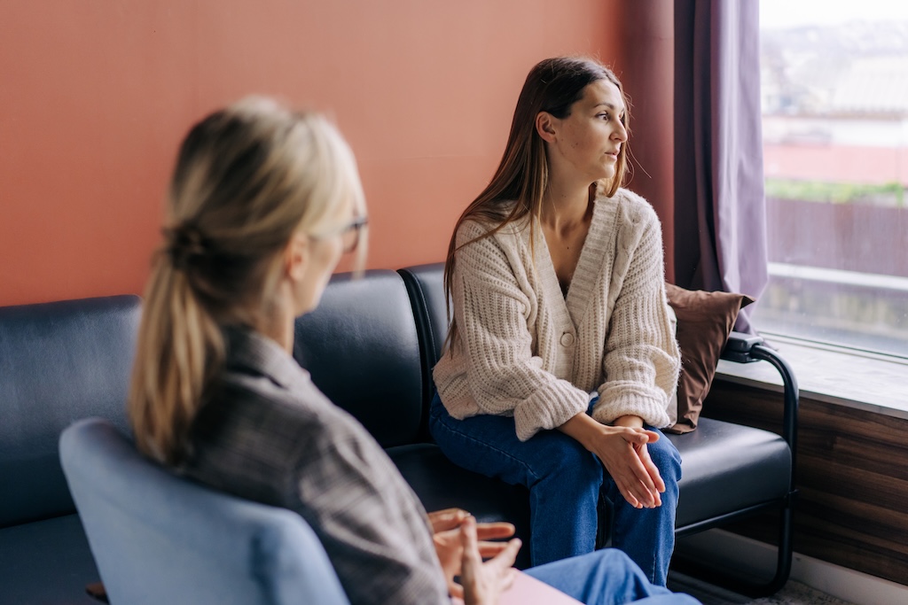 Sad frustrated woman talking in a session with a psychotherapist about her problems practicing DBT in treatment.