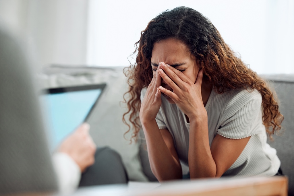 Woman sitting with head in her hands during a panic attack.