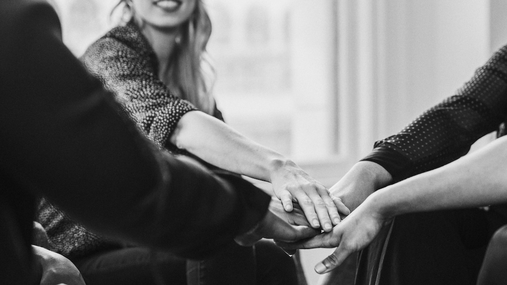 Group of rehab clients stacking hands in the middle