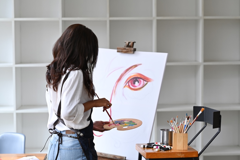 Woman expressing her emotions through creative art during therapy group.