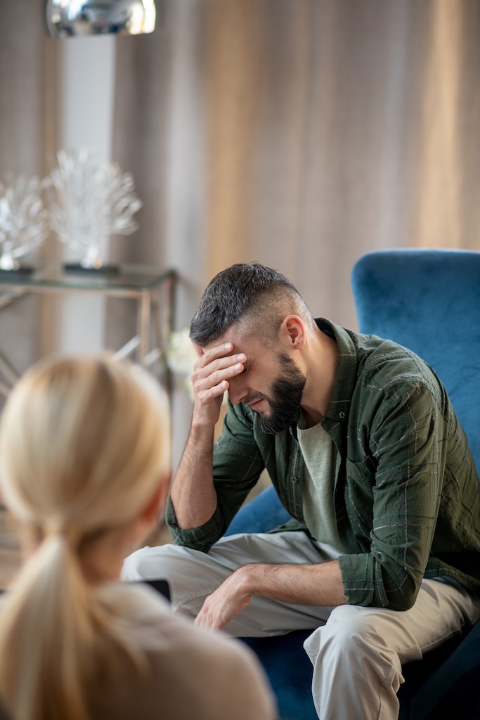 Darkhaired man talking about depression to psychologist