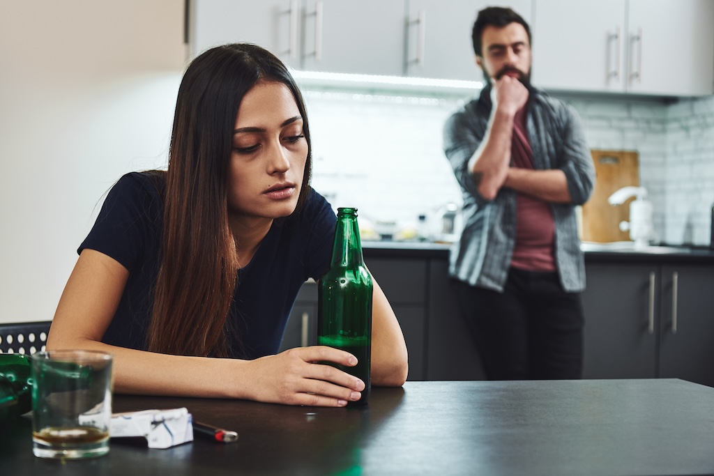 Sad, depressed woman with a beer.