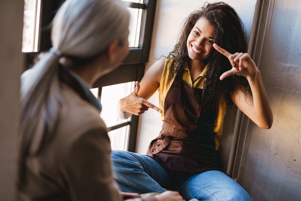 Mature instructor laughing and talking with her client during clinical group