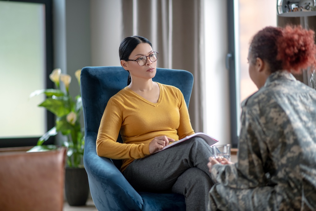 Psychoanalyst listening to woman wearing military uniform