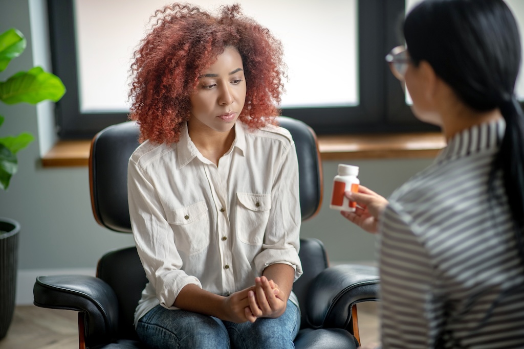 Psychiatrist discussing medications with female patient.